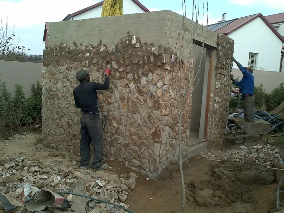 Natural stone cladding installation by Down2Earth landscapers on a custom garden structure in Pretoria